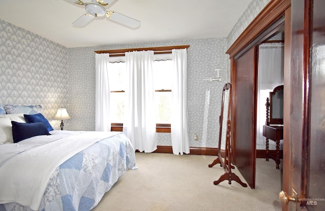 bedroom with baseboards, a ceiling fan, light colored carpet, and wallpapered walls