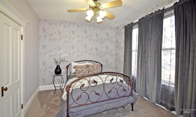 carpeted bedroom with ceiling fan, baseboards, and wallpapered walls