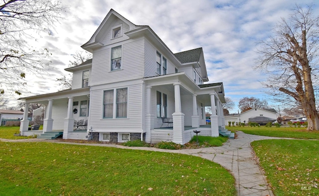 view of front of property with covered porch and a front lawn