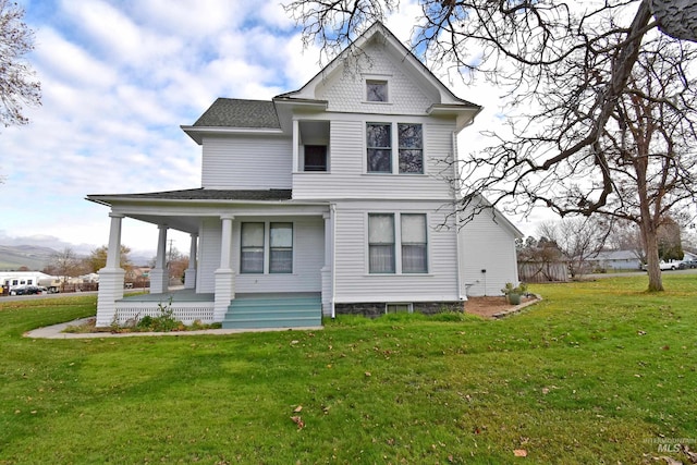 rear view of house featuring covered porch, roof with shingles, and a yard