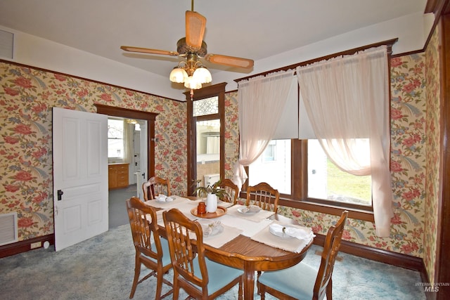 carpeted dining room featuring wallpapered walls, visible vents, and baseboards