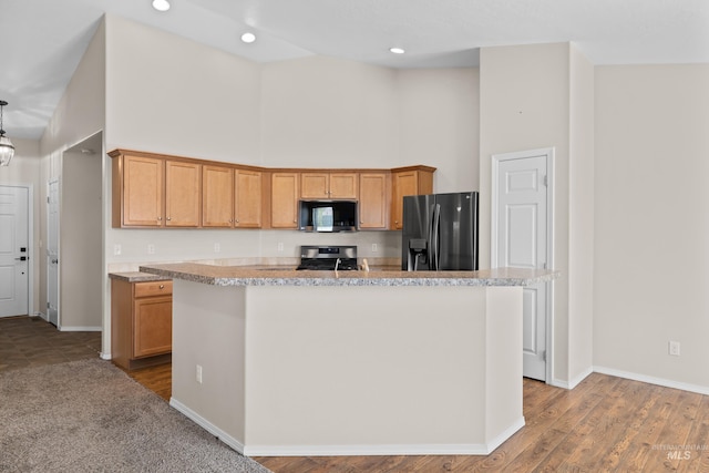 kitchen with stainless steel microwave, range with gas stovetop, fridge with ice dispenser, and a towering ceiling