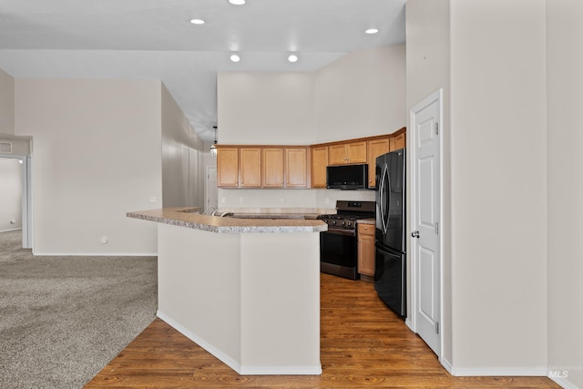 kitchen featuring baseboards, light countertops, recessed lighting, a towering ceiling, and black appliances