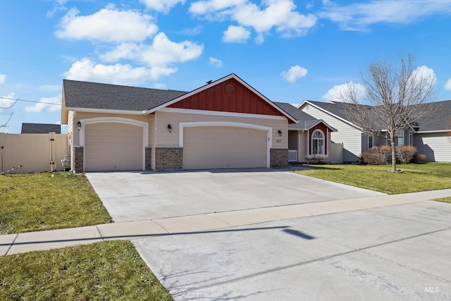 view of front facade featuring board and batten siding, an attached garage, a front yard, and fence