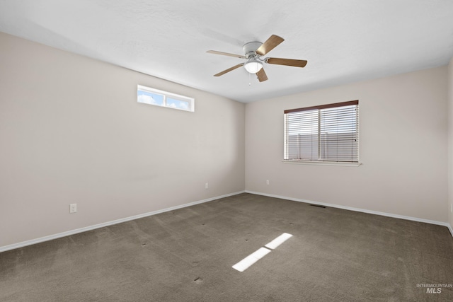 carpeted empty room featuring visible vents, baseboards, and a ceiling fan