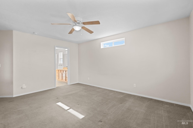 carpeted empty room featuring baseboards and ceiling fan