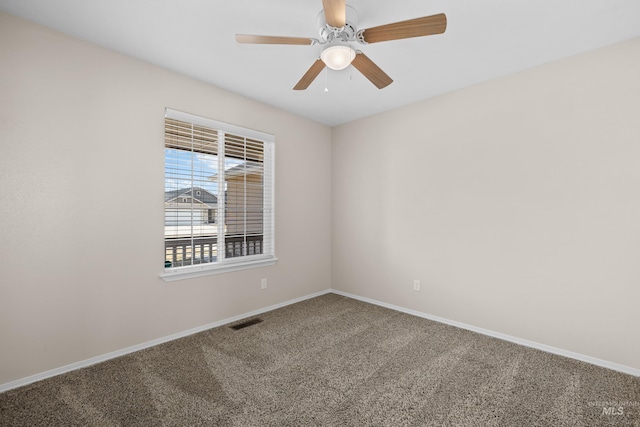 carpeted spare room featuring visible vents, a ceiling fan, and baseboards