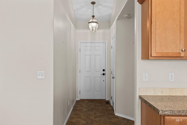 doorway to outside featuring baseboards