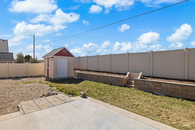 view of yard with a storage shed, a fenced backyard, an outbuilding, and a patio