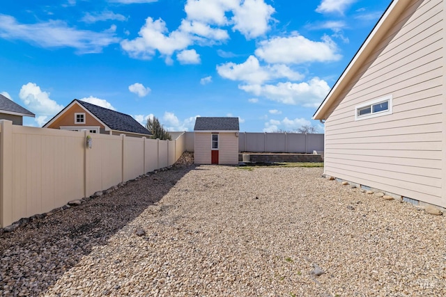 view of yard featuring a fenced backyard, a storage shed, and an outdoor structure