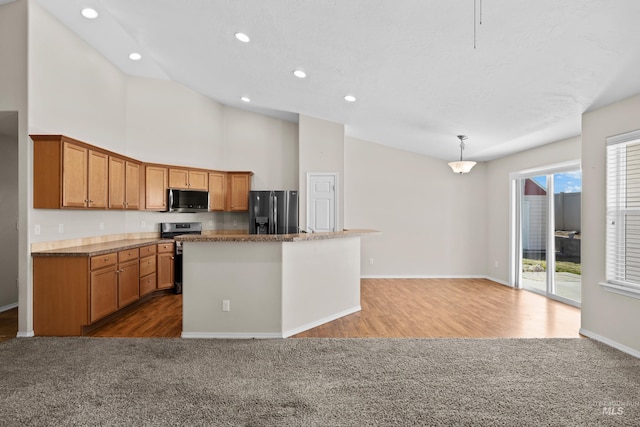 kitchen featuring pendant lighting, an island with sink, dark colored carpet, and stainless steel appliances