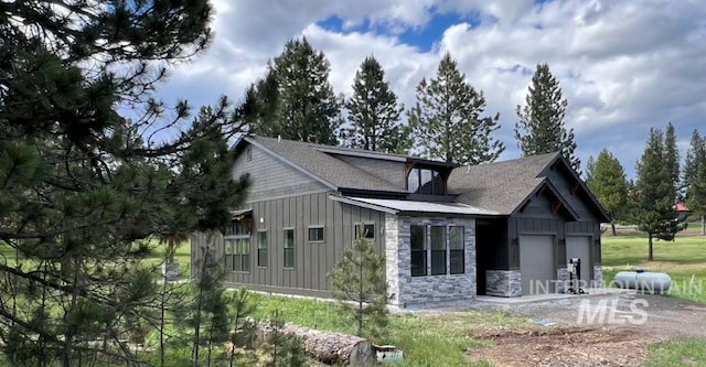 exterior space with stone siding, board and batten siding, and an attached garage