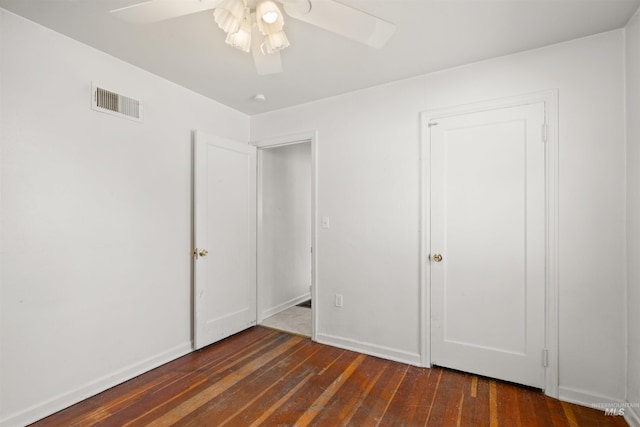 unfurnished bedroom with dark hardwood / wood-style flooring, a closet, and ceiling fan