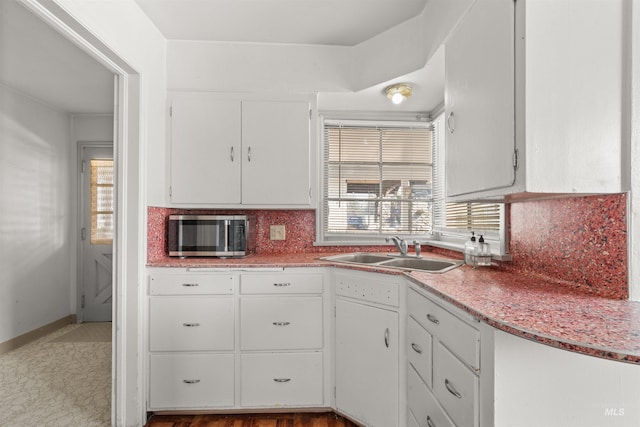 kitchen with white cabinetry, sink, and tasteful backsplash