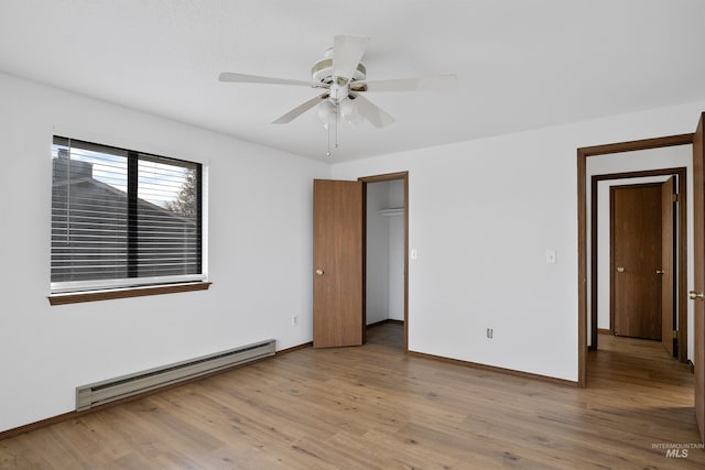 unfurnished bedroom with light wood finished floors, a ceiling fan, baseboards, and a baseboard radiator