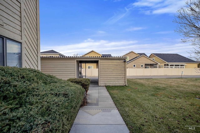 entrance to property featuring a yard and fence