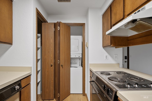 kitchen featuring under cabinet range hood, stovetop, light countertops, stacked washer / drying machine, and dishwasher