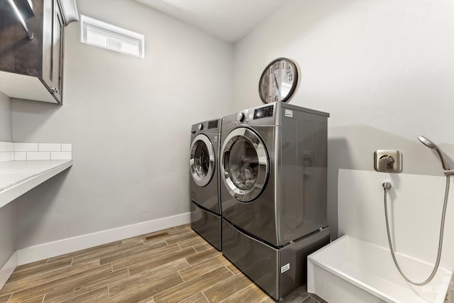 laundry area with washer and dryer, cabinet space, baseboards, and wood tiled floor