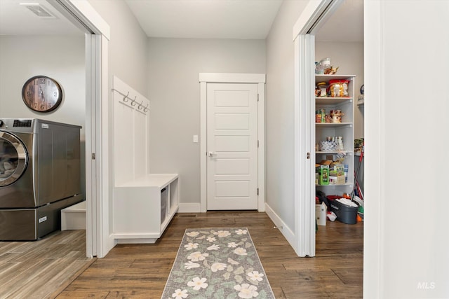 laundry room with laundry area, dark wood-type flooring, visible vents, baseboards, and washer / dryer