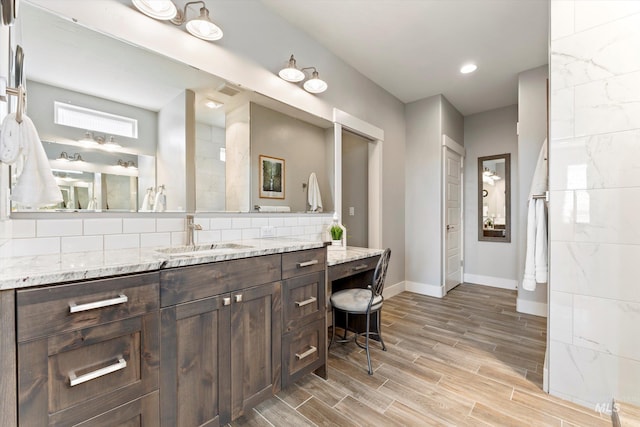 bathroom with baseboards, decorative backsplash, vanity, and wood tiled floor