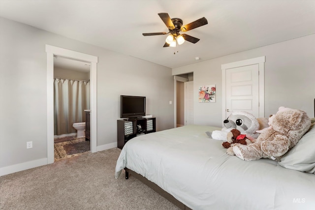 bedroom with carpet floors, ceiling fan, baseboards, and ensuite bathroom