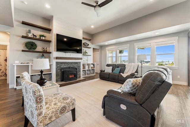 living area with plenty of natural light, baseboards, ceiling fan, and wood finished floors