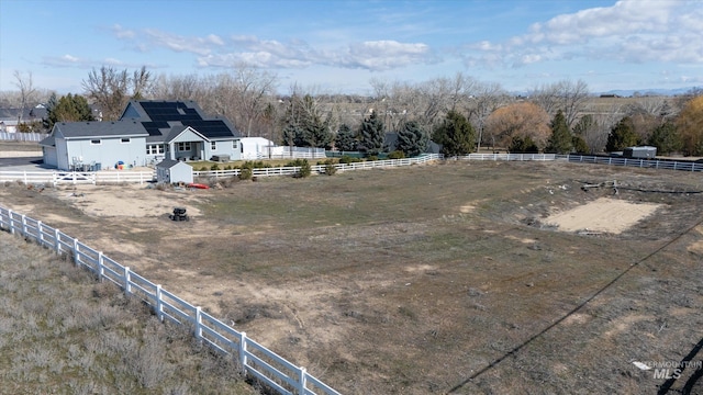 view of yard with an outbuilding, a rural view, and fence