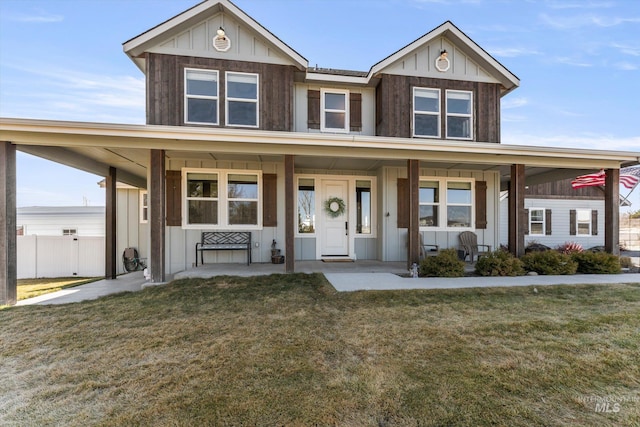 view of front of property with a porch, board and batten siding, a front yard, and fence