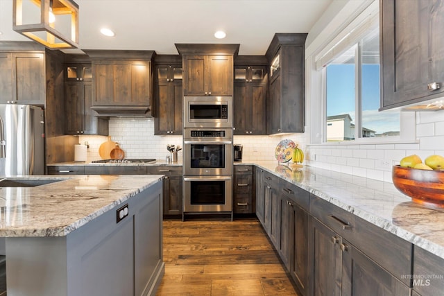 kitchen featuring dark wood-style floors, recessed lighting, backsplash, appliances with stainless steel finishes, and dark brown cabinets