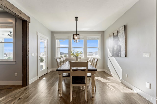 dining room with a ceiling fan, baseboards, and wood finished floors