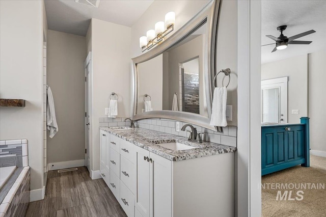 27985 Gray Sage Rd, Caldwell, ID 83607 - full bathroom featuring double vanity, a ceiling fan, baseboards, and tiled tub