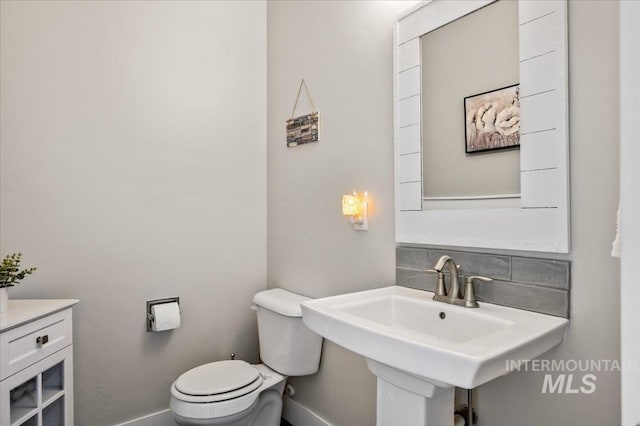 27985 Gray Sage Rd, Caldwell, ID 83607 - bathroom with toilet, baseboards, and decorative backsplash