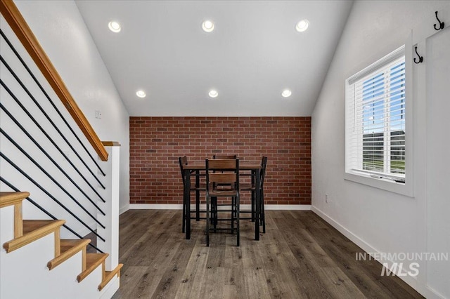 27985 Gray Sage Rd, Caldwell, ID 83607 - dining room with brick wall, baseboards, stairs, wood finished floors, and vaulted ceiling