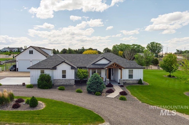27985 Gray Sage Rd, Caldwell, ID 83607 - view of front facade featuring curved driveway, board and batten siding, a garage, a front lawn, and stone siding