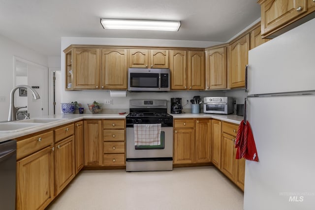 kitchen with light countertops, a sink, a toaster, and stainless steel appliances