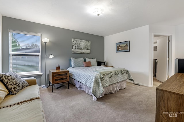bedroom featuring baseboards and light carpet