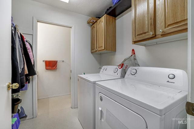 clothes washing area featuring light floors, cabinet space, baseboards, and washer and dryer