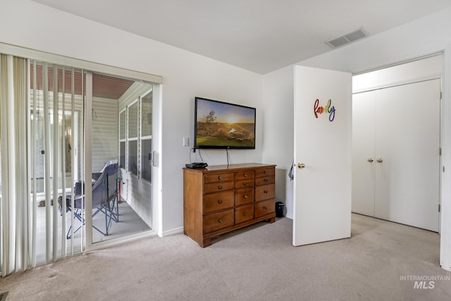 carpeted bedroom with visible vents and access to exterior