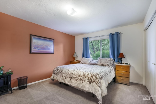 bedroom with light colored carpet, baseboards, and a closet