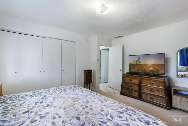 bedroom featuring light carpet, a closet, and visible vents