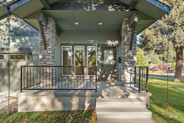 entrance to property with a lawn and a porch