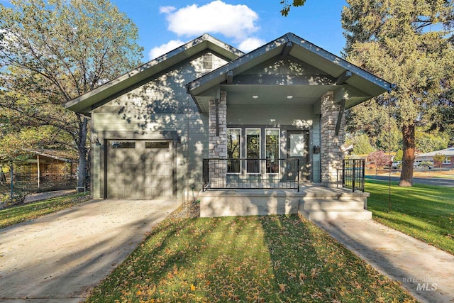 view of front of home featuring a porch, a front yard, and a garage