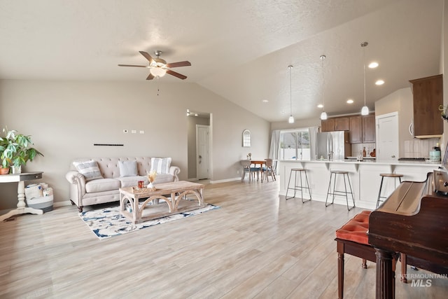 319 Magnolia Ave, Fruitland, ID 83619 - living area featuring vaulted ceiling, a ceiling fan, light wood-style flooring, recessed lighting, and baseboards