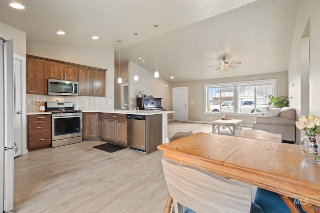 319 Magnolia Ave, Fruitland, ID 83619 - kitchen featuring appliances with stainless steel finishes, open floor plan, a peninsula, lofted ceiling, and a ceiling fan