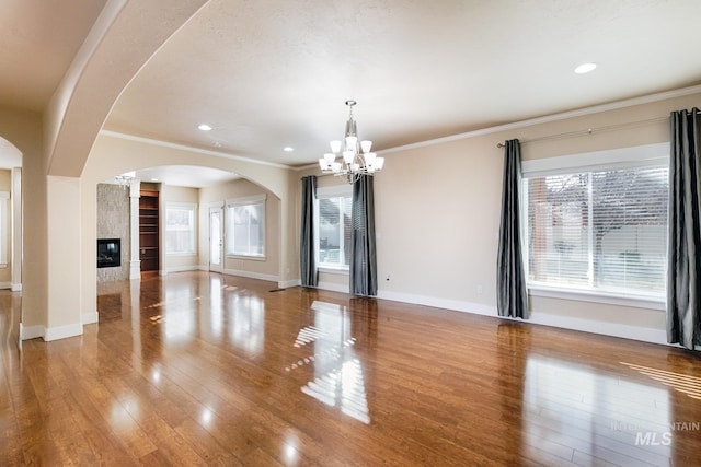 unfurnished living room featuring a fireplace, wood finished floors, and a healthy amount of sunlight