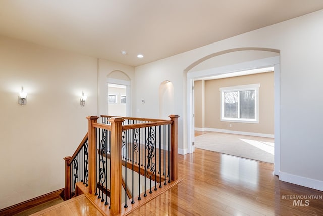 hall featuring wood finished floors, recessed lighting, an upstairs landing, and baseboards