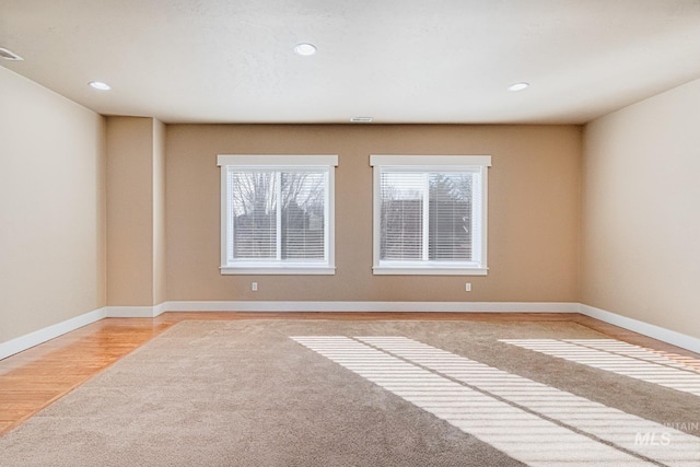 unfurnished room with light colored carpet, recessed lighting, and baseboards