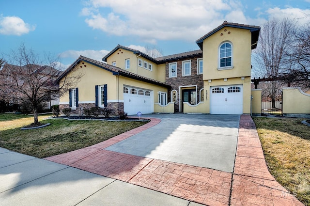 mediterranean / spanish house featuring stucco siding, concrete driveway, a front lawn, a garage, and stone siding