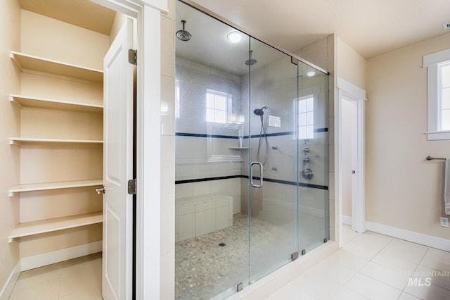 bathroom featuring tile patterned floors, a stall shower, and baseboards