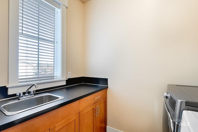 interior space featuring washing machine and clothes dryer, cabinet space, and a sink